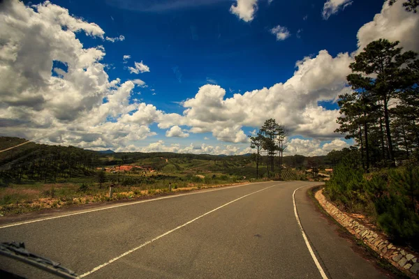 Carretera Soleada Doblar Contra Tierras Arboladas Montañosas Cielo Azul Nublado —  Fotos de Stock