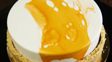 Tatlı parlak beyaz misk kek beyazla kaplı ve siyah zemin üzerine sarı sır hızlı kendi etrafında hareket eder