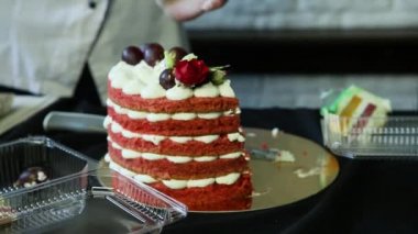 pudra eller kırmızı çok katlı pasta yarım kesilmiş beyaz bizet, üzüm ve kırmızı ve beyaz gül ile dekore edilmiştir.