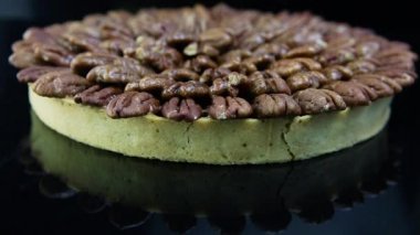 ev yapımı yuvarlak bisküvi pasta siyah ayna arka planda yukarıdan badem ile kaplı üzerinde Panorama