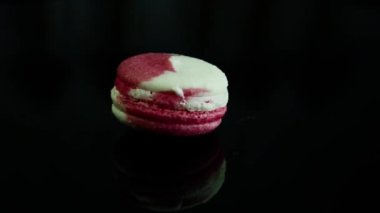 Fransız tatlı acıbadem kurabiyesi krem intercalaire ile yavaş yavaş siyah ayna backgrond üzerinde kendi etrafında döner