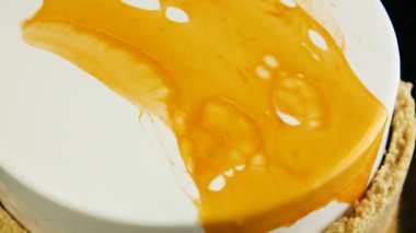 siyah zemin üzerine sarı sır kendi etrafında yavaş yavaş hareket eder ve closeup üstten görünüm parlak beyaz misk pastadan beyazla kaplı