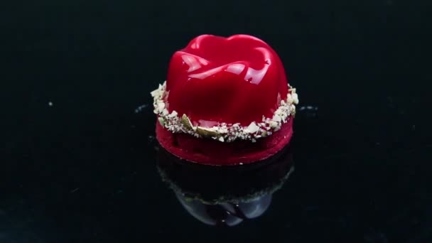 パノラマ右上の赤いムース デザート ココナッツ削りで飾られ 反射ミラー黒背景が付いて赤い釉薬でコーティング — ストック動画