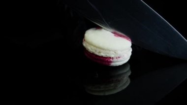 Beyaz ve pembe Fransız tatlı acıbadem kurabiyesi krem intercalaire yalan üzerine siyah ayna backgrond ile