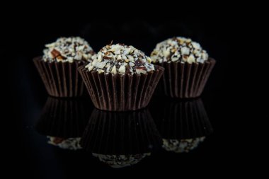 üç siyah ayna arka plan üzerinde hizmet hindistancevizi talaşı ile topu küçük çikolata şekerleme yuvarlak