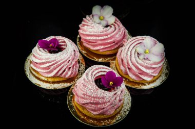 dört el yapımı pembe zephyr tanımlama bilgisi üstten görünüm yukarıdan siyah ayna arka plan üzerinde mor ve beyaz çiçeklerle dekore edilmiş