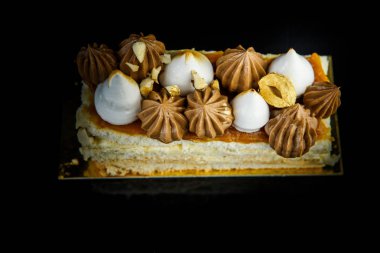 Üstten Görünüm çift katmanlı Kiev kek parçası üzerinde bol bol çikolatalı krema ve fındık portre siyah ayna arka plan yansıması ile süslenmiş