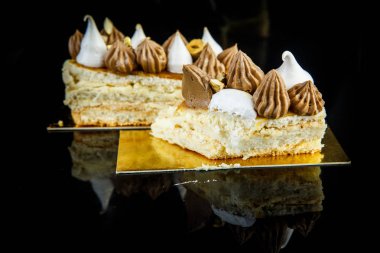 lezzetli çift katmanlı Kiev pasta kesilerek parçası bol çikolatalı krema ve fındık portre siyah ayna arka plan yansıması ile süslenmiş