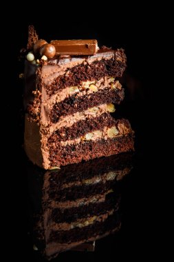 krem lezzetli çikolatalı kek parçası closeup Inter çikolata şeker siyah ayna arka plan üzerinde hizmet süslenmiş katmanı