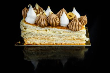 Çift katmanlı Kiev kek parçası closeup bol çikolatalı krema ve fındık portre siyah ayna arka plan yansıması ile süslenmiş