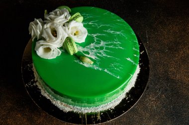 sırlı yeşil kek dekore edilmiş beyaz çiçekler, Hindistan cevizi cips ve macaroons ile tepesi