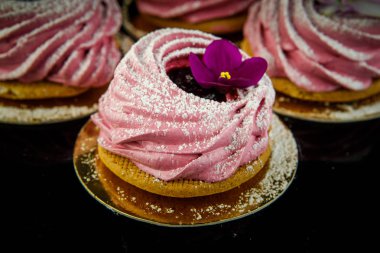 siyah ayna arka plan üzerinde Menekşe çiçek ile dekore edilmiş lezzetli pembe zephyr tanımlama bilgisi