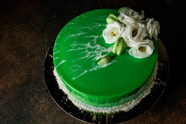 Üstten Görünüm ev yapımı Mus kek yeşil ayna sır, beyaz gül, Hindistan cevizi cips ve macaroons ile dekore edilmiş