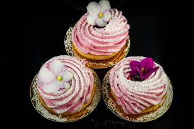 Üstten Görünüm üç pembe zephyr tanımlama bilgisi yukarıdan siyah ayna arka plan üzerinde mor ve beyaz çiçeklerle dekore edilmiş