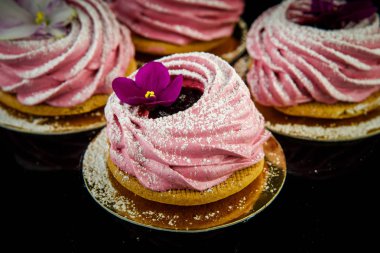 Menekşe çiçek siyah ayna arka plan olarak el yapımı pembe zephyr çerez süslenmiş