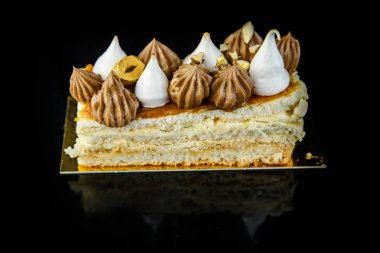 ev yapımı çift katmanlı Kiev kek parçası bol çikolatalı krema ve fındık portre siyah ayna arka plan yansıması ile süslenmiş