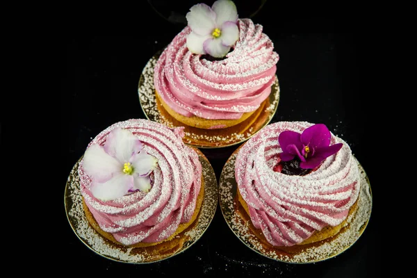 Üstten Görünüm üç pembe zephyr tanımlama bilgisi yukarıdan siyah ayna arka plan üzerinde mor ve beyaz çiçeklerle dekore edilmiş