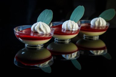 blackberry panakota tatlı krem ve siyah ayna arka plan üzerinde cam kase otlar ile dekore edilmiş