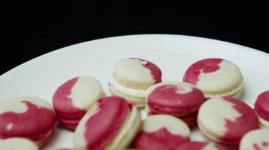 lezzetli whithe ve pembe Fransız tatlı macaroons ile beyaz plaka üzerinde krem intercalaire