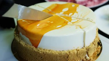 pudra eller bıçak parlak mousse kek tarafından kesilmiş siyah arka plan üzerine beyaz ve sarı sır ile kaplı
