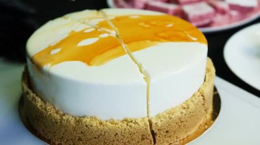 pudra eller bıçak parlak mousse kek tarafından kesilmiş siyah arka plan üzerine beyaz ve sarı sır ile kaplı