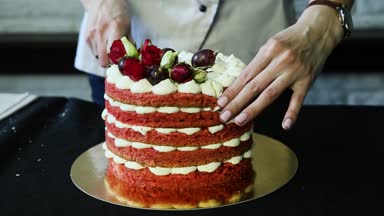 pudra eller kırmızı çok katlı pasta kesme beyaz bizet, üzüm ve kırmızı ve beyaz gül ile dekore edilmiş iki parçaya