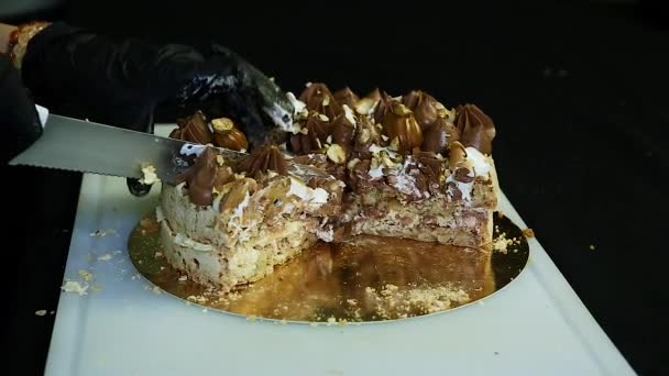 糖果手切开的刀双层基辅蛋糕 丰富的装饰与巧克力奶油和坚果白色背景 — 图库视频影像