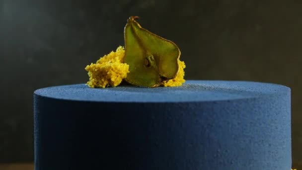 特写现代蓝色圆蛋糕装饰与干梨和一块黄色海绵蛋糕慢慢地移动在本身附近 — 图库视频影像
