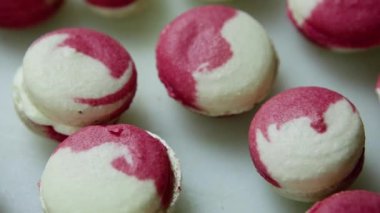 Birçok Fransız tatlı macaroons üzerinde beyaz backgrond krem intercalaire ile üzerinde aşağı Panorama