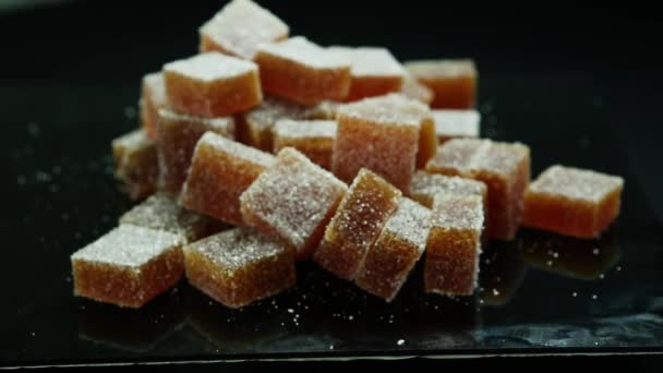 Grote Groep Oranje Marmelade Stukken Bedekt Met Suiker Zwarte Spiegel — Stockvideo