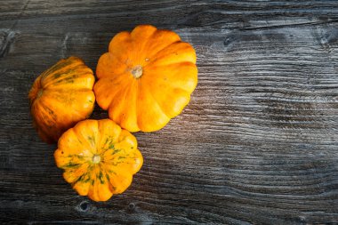 Masanın üzerinde çeşitli dekoratif sarı balkabakları var.