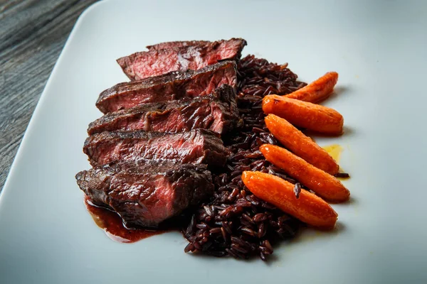 Carne cortada a la parrilla finamente decorada con arroz y zanahoria —  Fotos de Stock