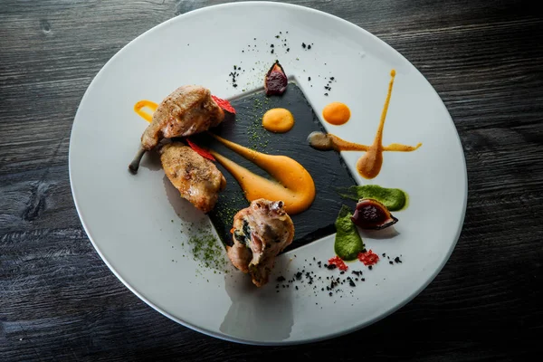 Trendy restaurant dish of baked quail legs with assorted sauces — Stock Photo, Image