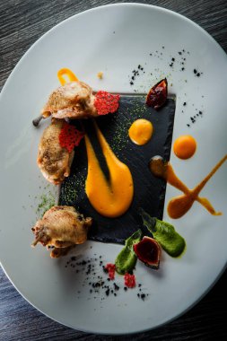 Kızarmış bıldırcın bacağının modern restoran yemeğinin dikey görüntüsü