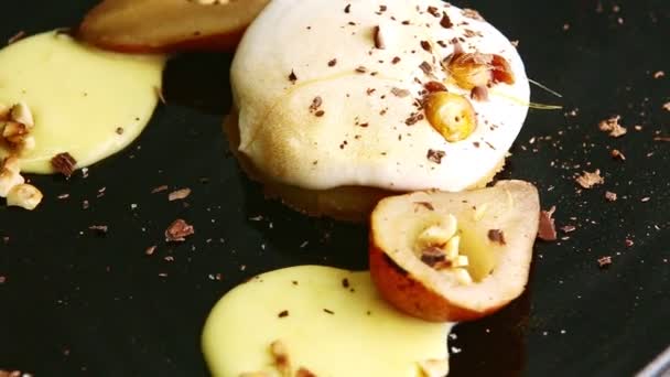 Closeup finely decorated dessert on black plate spinning around — 비디오