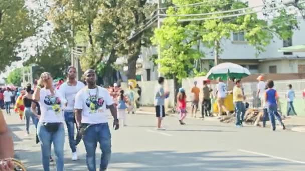 Personas dominicanas en trajes coloridos caminan en el evento anual de carnaval tradicional — Vídeos de Stock