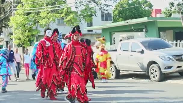 Les gens en costumes de démon marchent sur la rue de la ville dominicaine à l'événement annuel du carnaval — Video