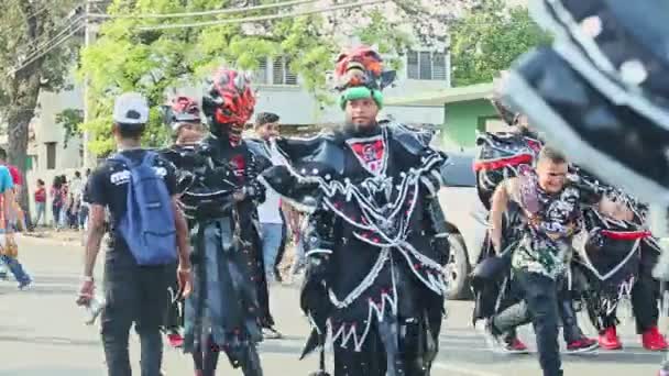Люди позируют в страшных костюмах демонов на традиционном доминиканском карнавале — стоковое видео