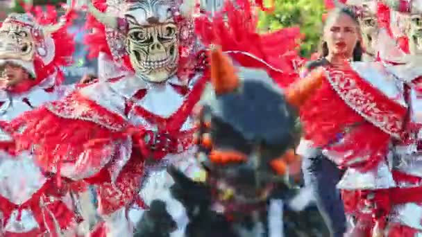 Hombres con trajes brillantes de demonios marchan en el tradicional evento anual de carnaval dominicano — Vídeo de stock