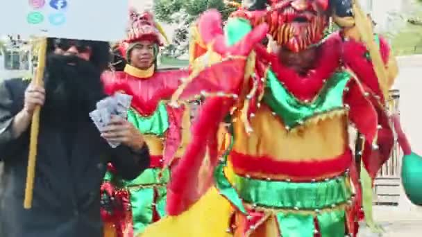 Men in colorful demon costumes walk at traditional Dominican carnival annual event — Stock Video
