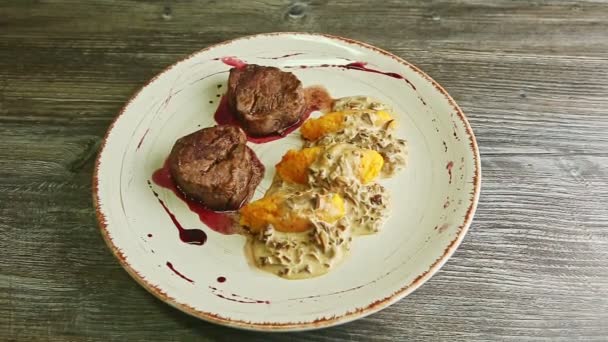 Медленное увеличение на изысканные украшенные кусочки жареного мяса с соусом и картофельным гарниром — стоковое видео