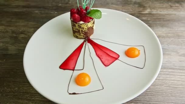 Vergrößern bei leckerem Himbeer-Sahne-Dessert auf weißem Teller — Stockvideo