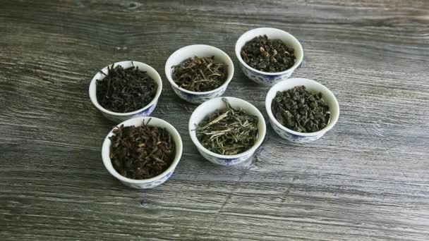 Closeup human hand takes away small vessels with assorted dry tea leaves — 图库视频影像