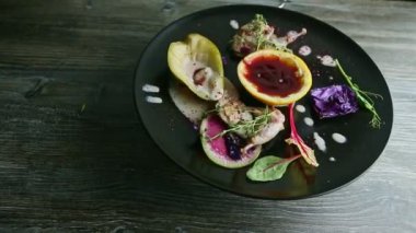Lezzetli kızarmış bıldırcın bacakları siyah tabakta dönüyor.