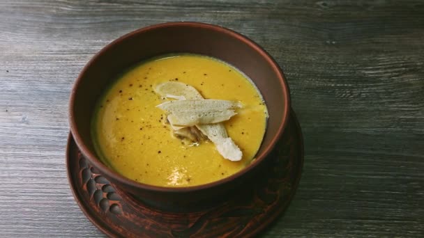 Вид зверху на жовтий крем-суп, дрібно прикрашений грибами та сушеним хлібом — стокове відео