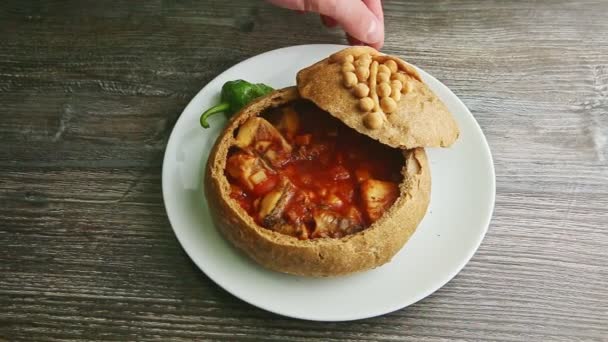 Human hand rotates plate with exquisite decorated fish soup in brown bread bowl — 비디오