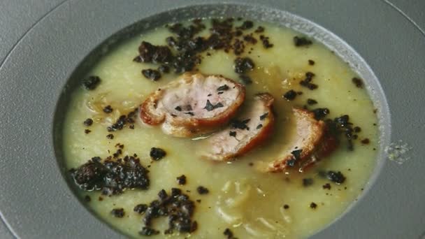 Primer plano panorama abajo en sopa de crema de cebolla decorada con lonchas de salchicha — Vídeos de Stock