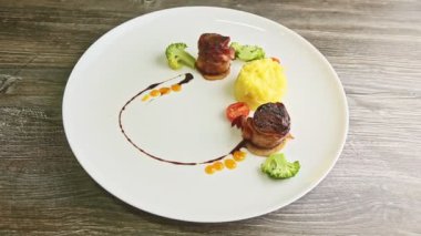 Domuz pastırması ve püre ve brokoli ile kızartılmış ince dekore edilmiş et parçaları.