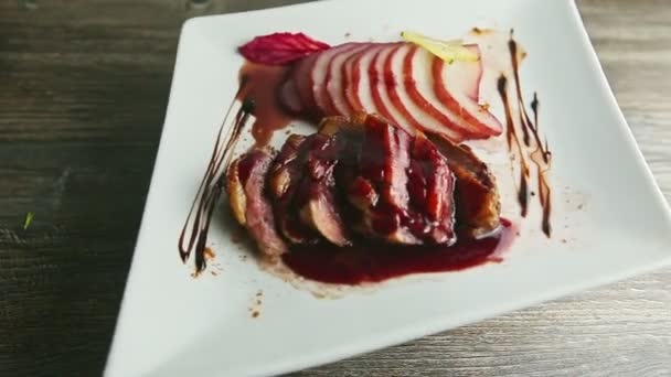 Exquisite decorated roasted sliced duck breast rotates on white plate — 비디오