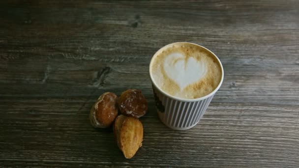 Man hand sätta cappuccino kopp bredvid en annan och mandel kakor — Stockvideo